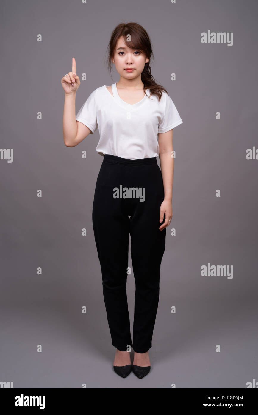 Full length shot of young Asian woman standing Stock Photo - Alamy