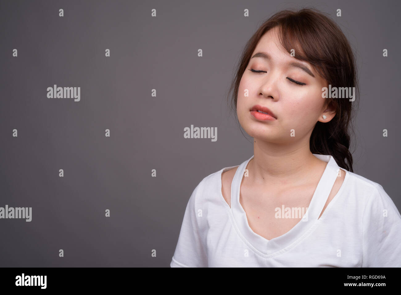Young beautiful Asian woman relaxing with eyes closed Stock Photo - Alamy