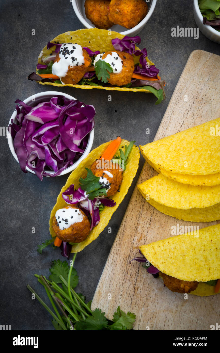 Sweet potato falafel in taco shells, with red cabbage, salad, carrot, yogurt sauce and black sesame Stock Photo