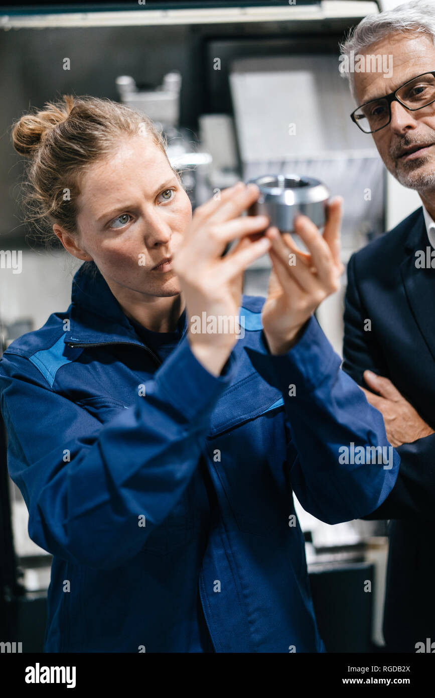 Manager and skilled worker in high tech enterprise, checking machine parts Stock Photo