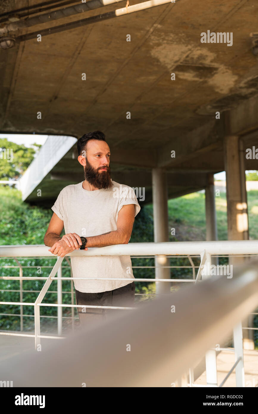 Bearded young man outdoors looking sideways Stock Photo