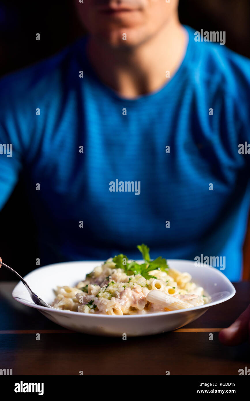 Close-up of athlete eating pasta dish Stock Photo
