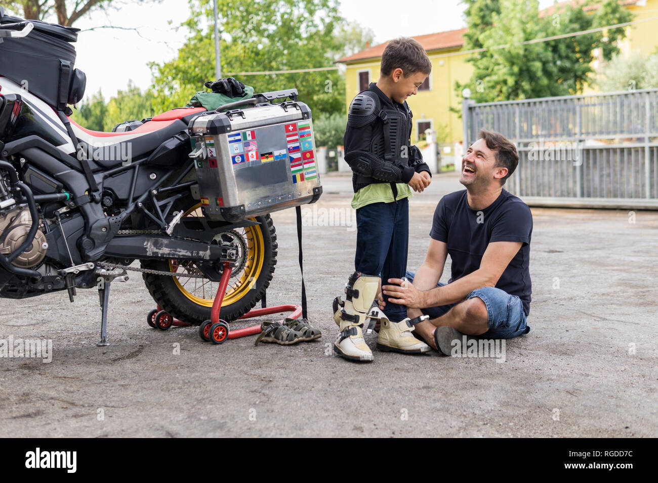 Happy father and son next to a motorbike Stock Photo