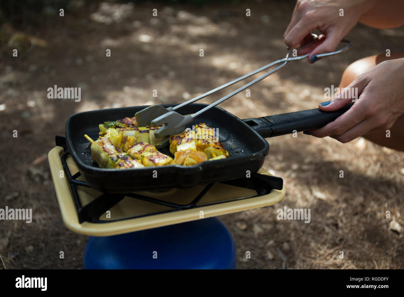 Woman frying vegetable skewer on gas cooker, close-up Stock Photo