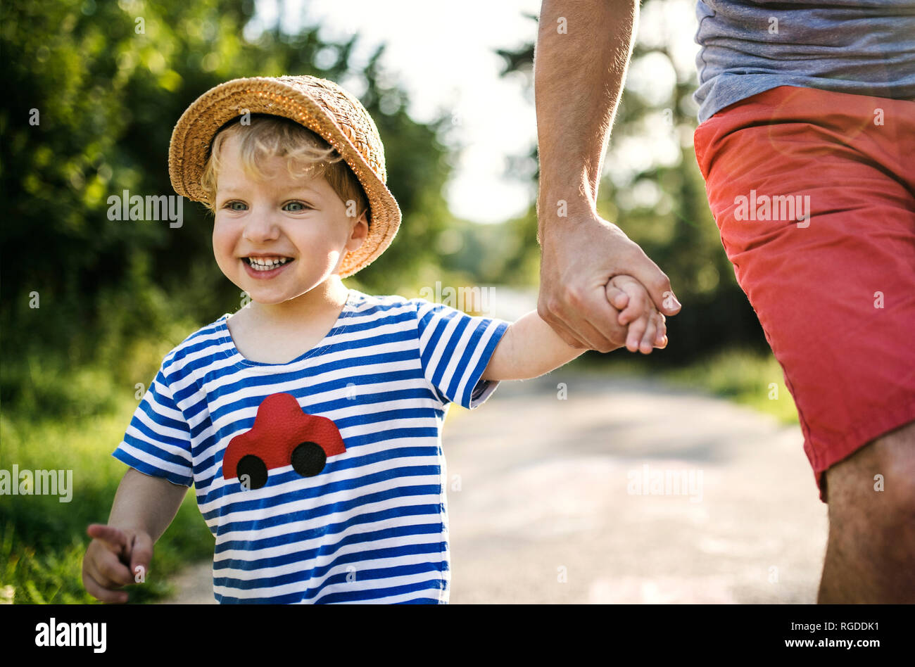 Portrait of laughing toddler walking on father's hand Stock Photo