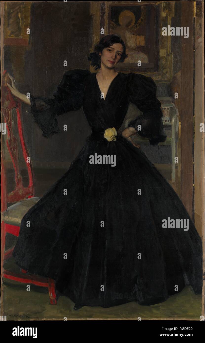 she's dressed in black in spanish Spanish, Beautiful, Brunette Flamenco Dancer with a Typical Flamenco Dress in Black with White Polka Dots. she is Dancing in the Stock Image