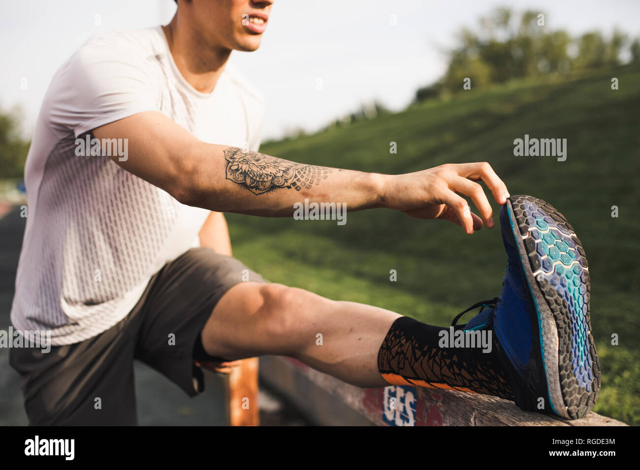 Male athlete doing warm-up exercises on a running track Stock Photo