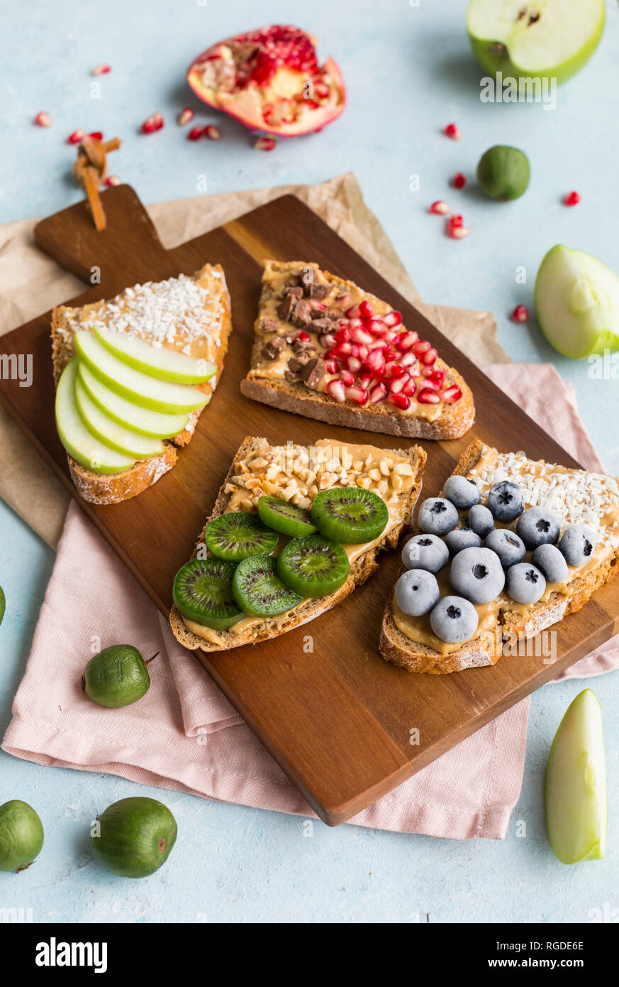 Bread slices with various toppings on wooden board Stock Photo