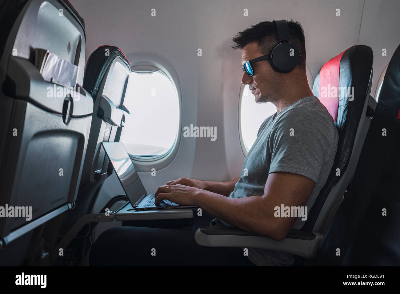 Man headphone laptop plane hires stock photography and images Alamy