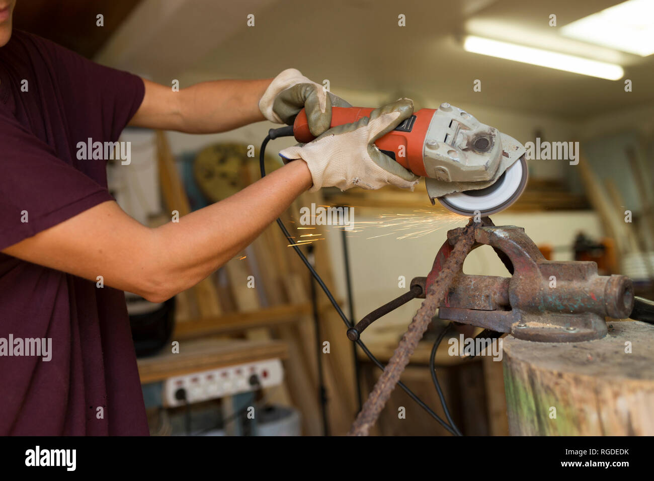 Craftswoman using angle grinder in her workshop Stock Photo