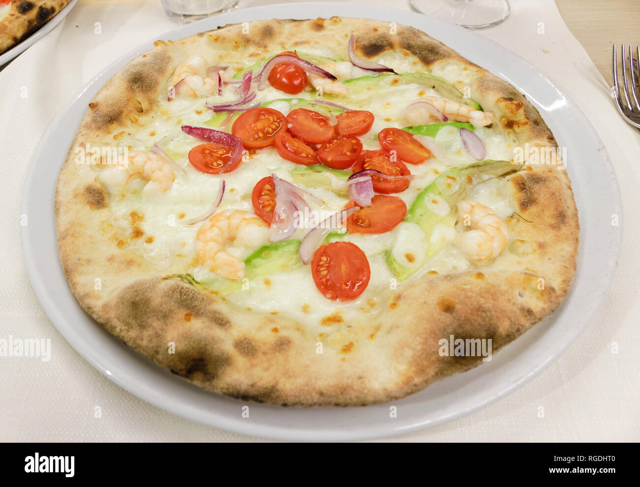 pizza with quinoa flour, avocado, shrimp, cherry tomatoes, onion. Stock Photo