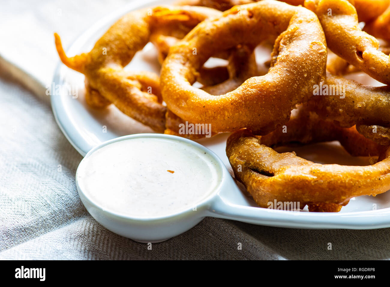 Golden onion rings on rustic table with sauce Stock Photo - Alamy