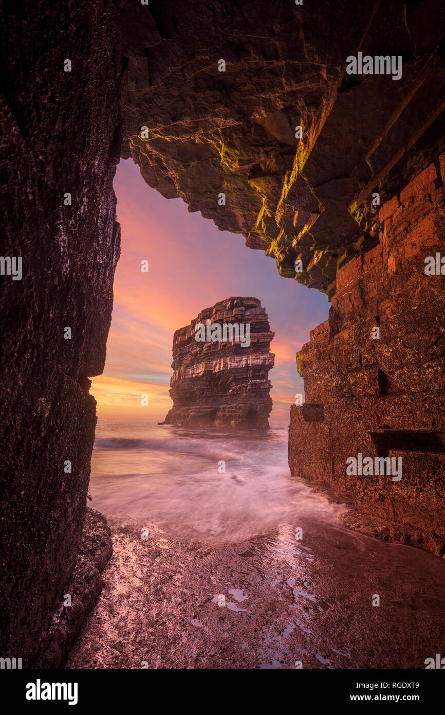 Sunset at Dun Briste sea stack from a cave beneath Downpatrick Head. County Mayo, Ireland. Stock Photo