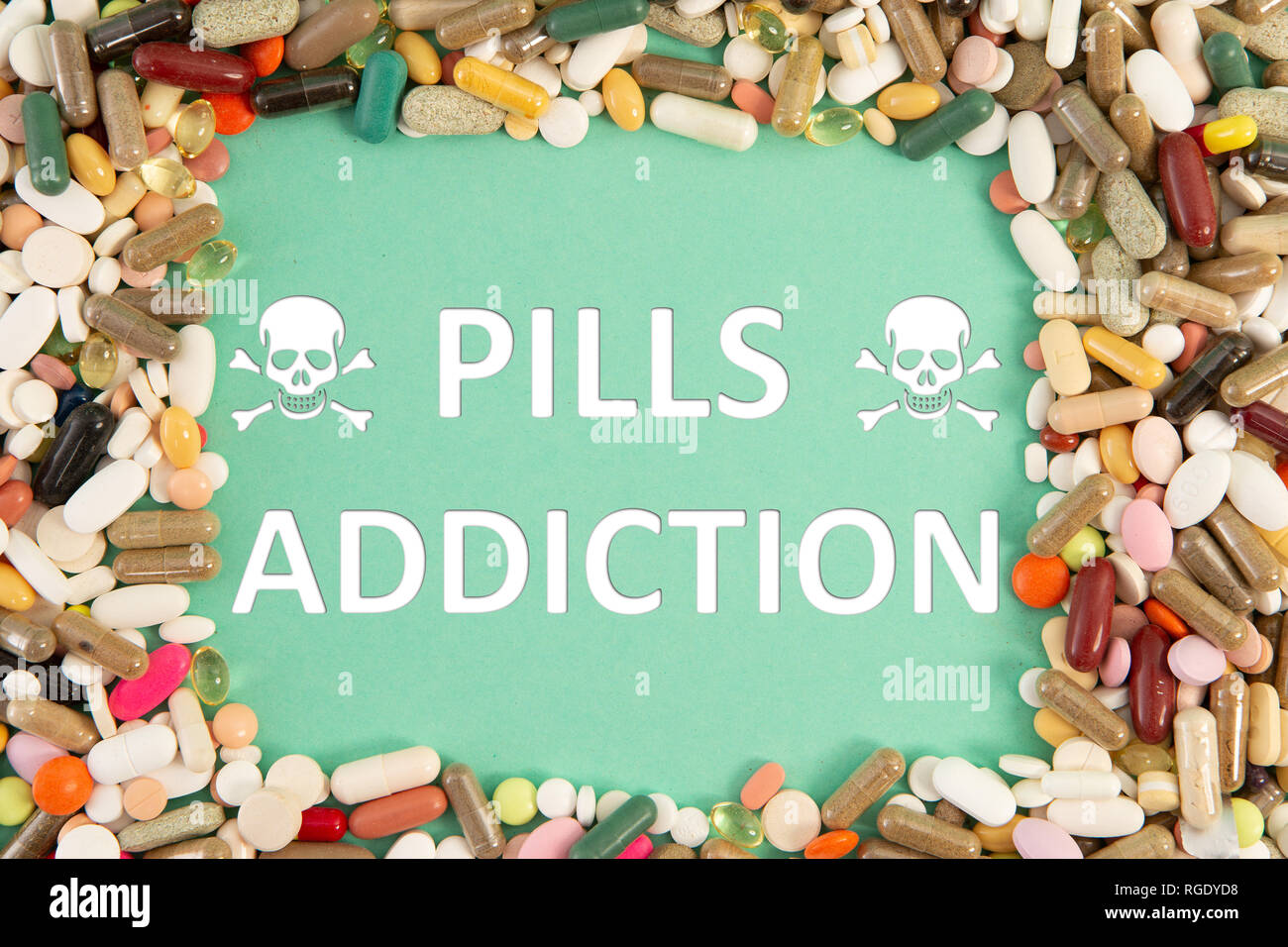 Pills addiction text and health hazard skulls symbol with colourful medicine frame on blue background Stock Photo