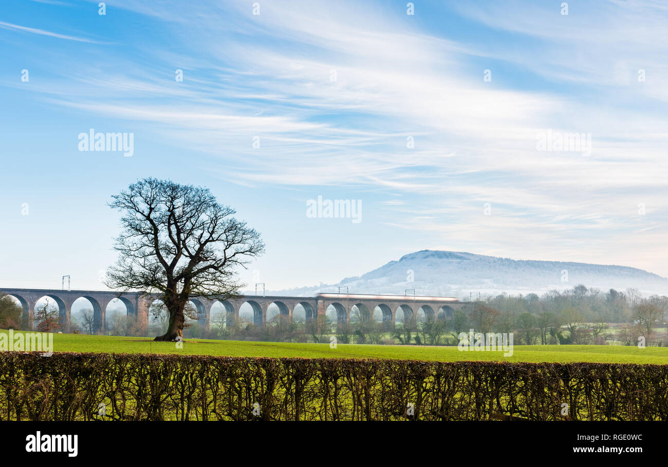 Manchester to London train on viaduct in Bosley with snowy Bosley Cloud escarpment in the background Stock Photo