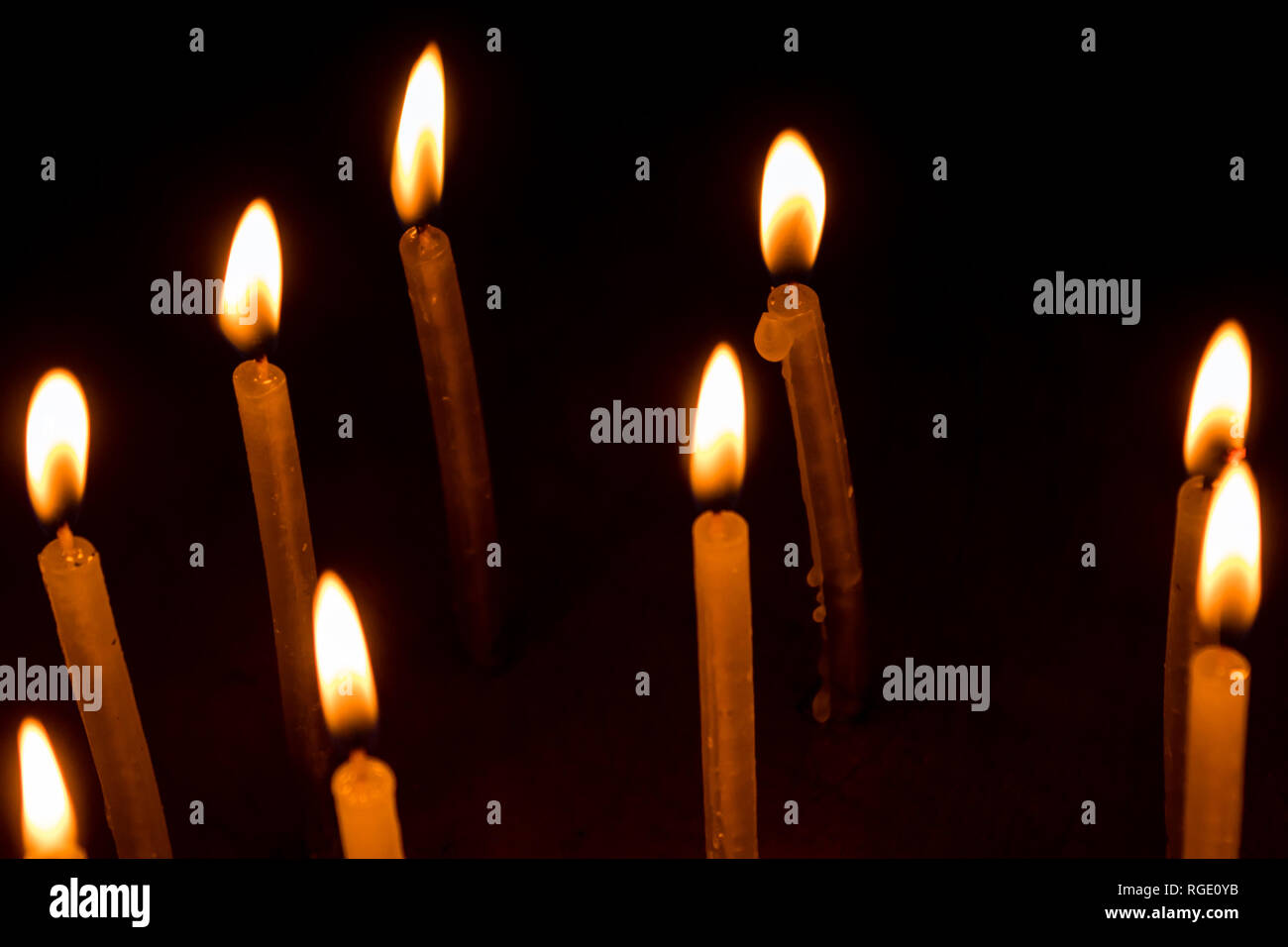 Many christmas candles burning at night on the black background. Candle