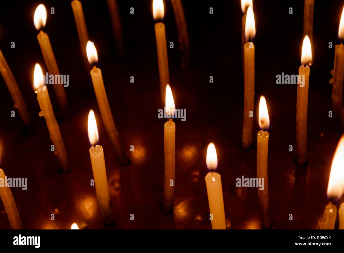 Many christmas candles burning at night on the black background. Candle