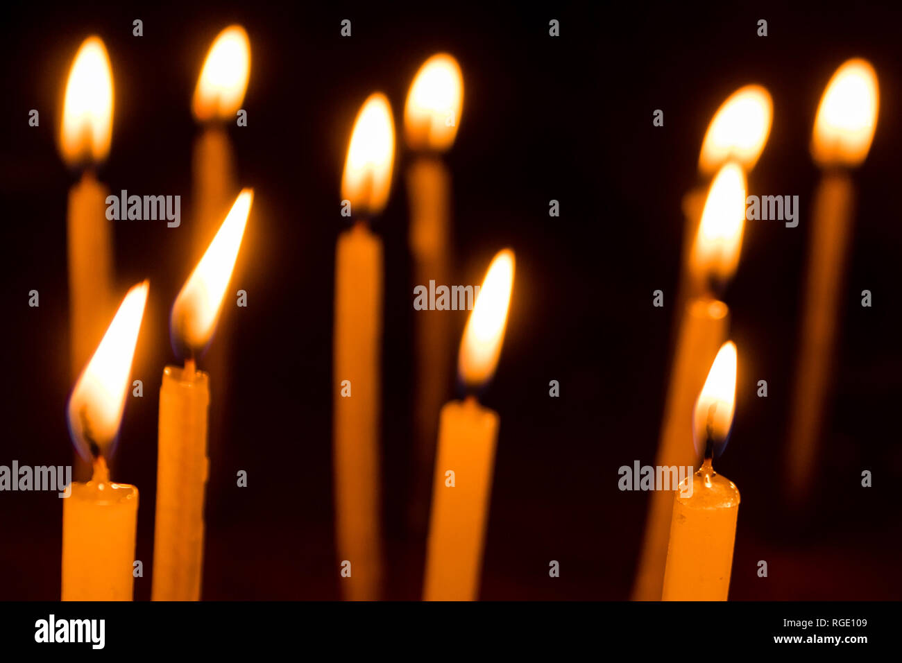 Many christmas candles burning at night on the black background. Candle