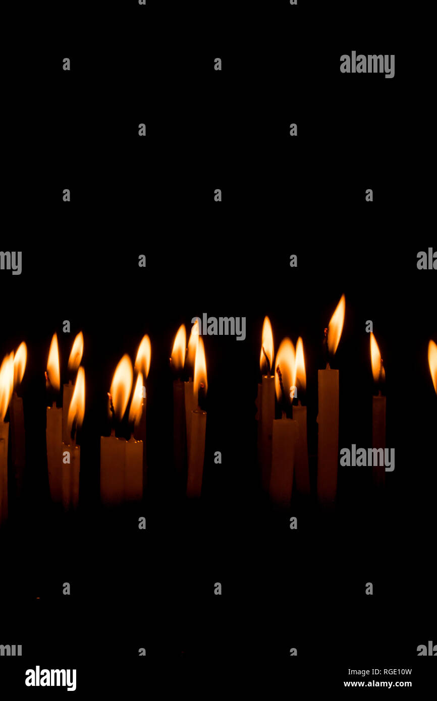 Many christmas candles burning at night on the black background. Candle