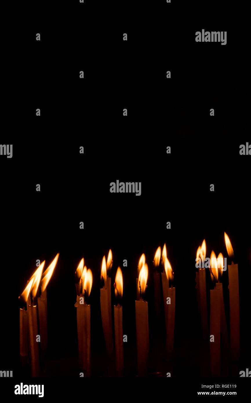 Many christmas candles burning at night on the black background. Candle
