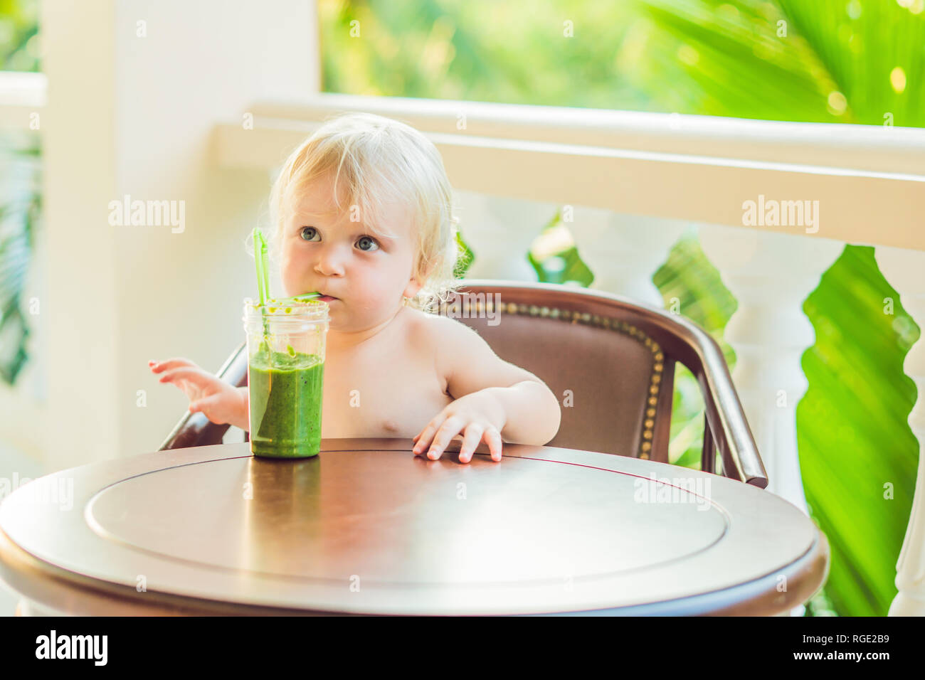 Child boy drinking healthy green vegetable smoothie healthy eating