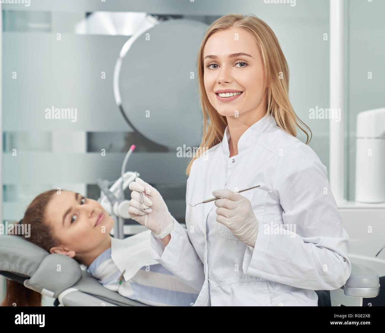 Beautiful woman, doctor of dentistry wearing in white lab coat, gloves