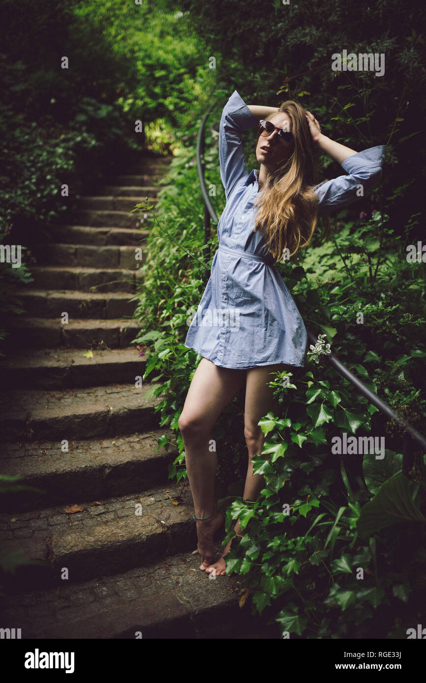 beautiful young girl in a blue dress posing on stairs outdoors wearing ...