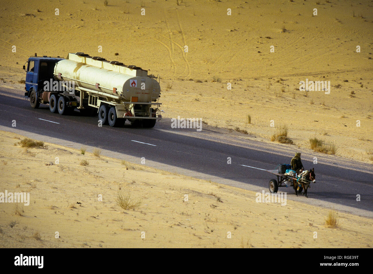 BORDJ EL HAOUAS, ALGERIA - JANUARY 16, 2002: Off-road vehicles and means of transport along the long straight in the Sahara desert, Algeria, North Afr Stock Photo