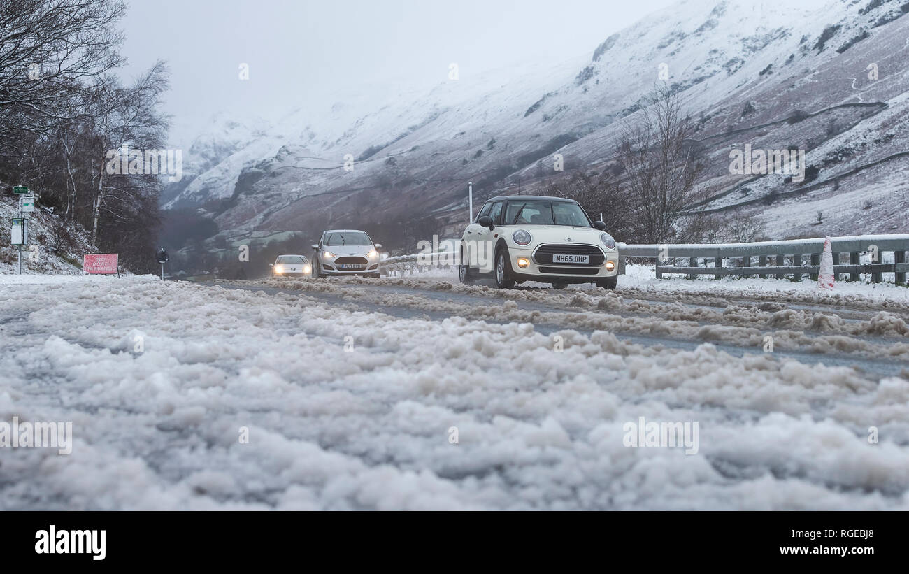 Thirlmere, Keswick, Cumbria. 29th Jan 2019. UK Weather: Cars battle the bad road conditions on the A591 between Keswick and Ambleside, during snowy conditions at Thirlmere, Keswick, Cumbria, UK. 29th January 2019. Photograph by Richard Holmes. Credit: Richard Holmes/Alamy Live News Stock Photo