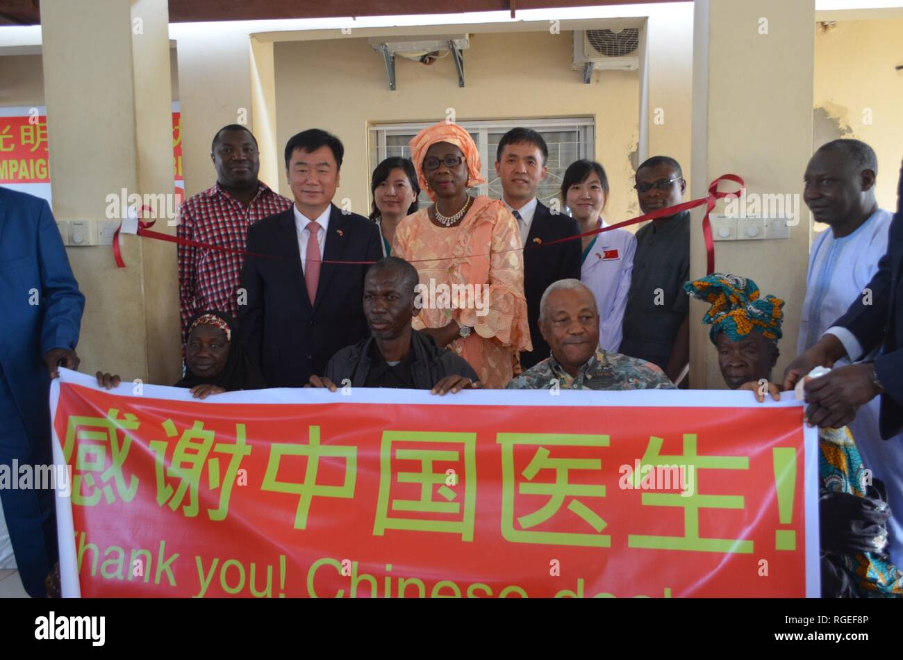 (190129) -- BANJUL, Jan. 29, 2019 (Xinhua) -- Gambian patients and their relatives pose for photos with a banner expressing their gratitude for the Chinese doctors in Banjul, the Gambia, Jan. 23, 2019. The Gambia, sitting at the western coast of the African continent, has plenty of sunshine and comparatively high prevalence of cataract. Many cataract patients suffer from blurred vision, even blindness, as the country lacks medical expertise and equipment. Ten Chinese doctors volunteered to provide free treatment to patients in this country under China's medical aid program 'Bright Jour Stock Photo