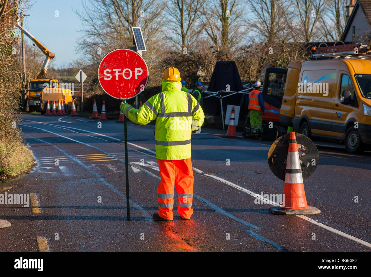 Carrigaline, Cork, Ireland. 29th January, 2019. An electric company stop and go man controls traffic flow while engineers work on power lines in Carrigaline, Co. Cork, Ireland Credit: David Creedon/Alamy Live News  Stock Photo
