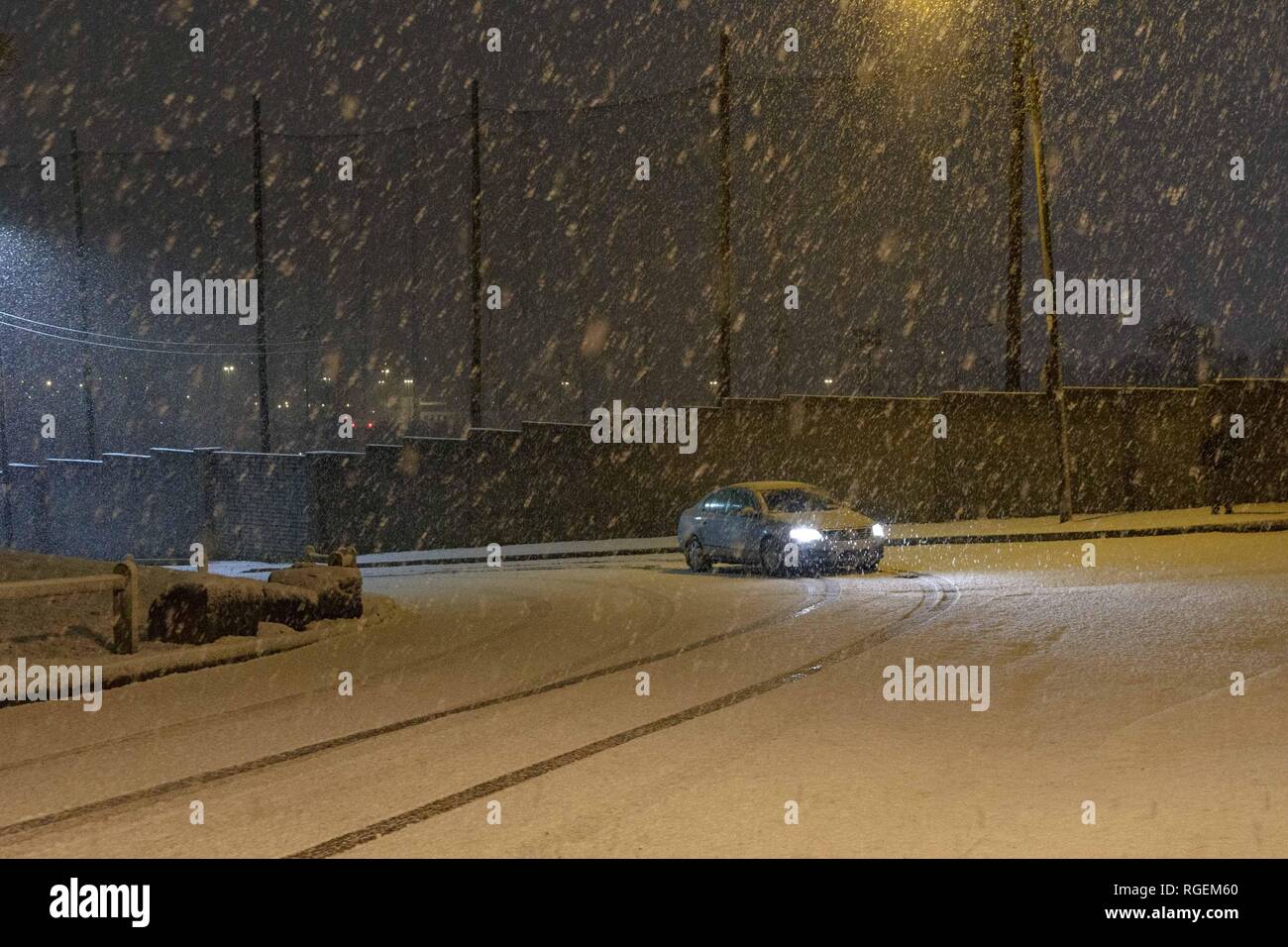 Cork, Ireland, 29th January, 2019.   Snow in Ballyvolane, Cork City. Today a Yellow Weather Warning was put in place accross the country by MET Eireann for ice and snow. Heavy snowfall hit parts of Cork City and County throughout the day making some roads treacherous and driving particulary dangerous throughout the city. Pictured here is a car attempting to drive up Ballincollie Road. Credit: Damian Coleman/ Alamy Live News. Stock Photo