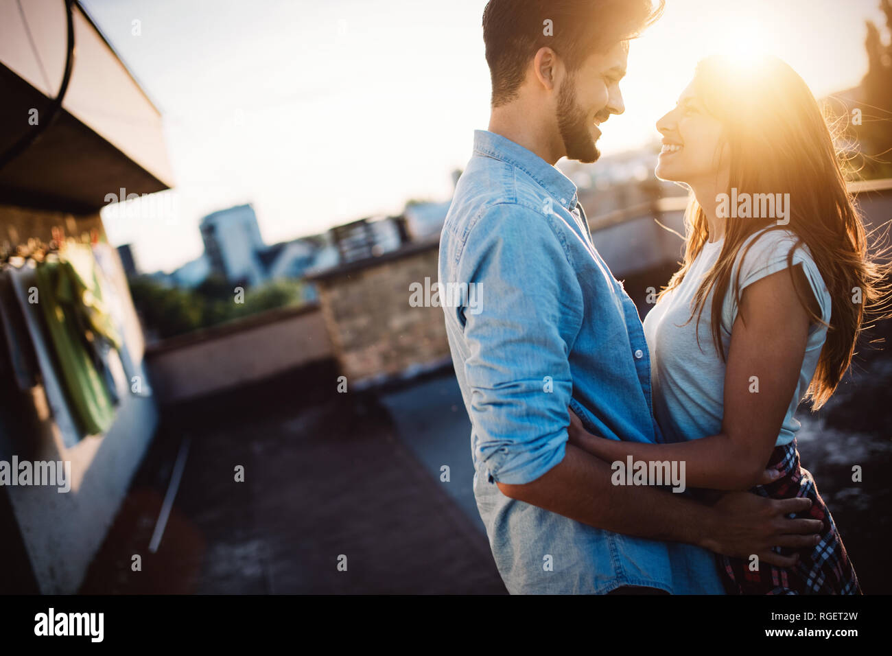 Couple in love enjoying in sunset in a terrace Stock Photo