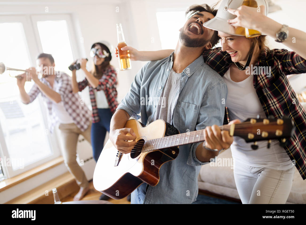 Small group of young people hang out at the house party, friends having