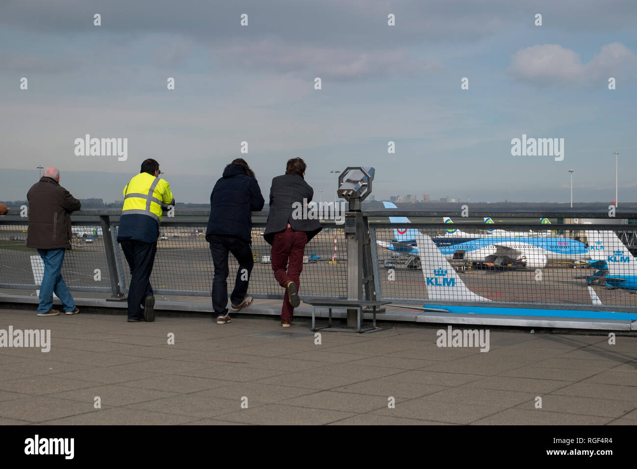 At the plane observation deck at Schiphol airport in Amsterdam in the Netherlands. People watching KLM planes take off. Stock Photo