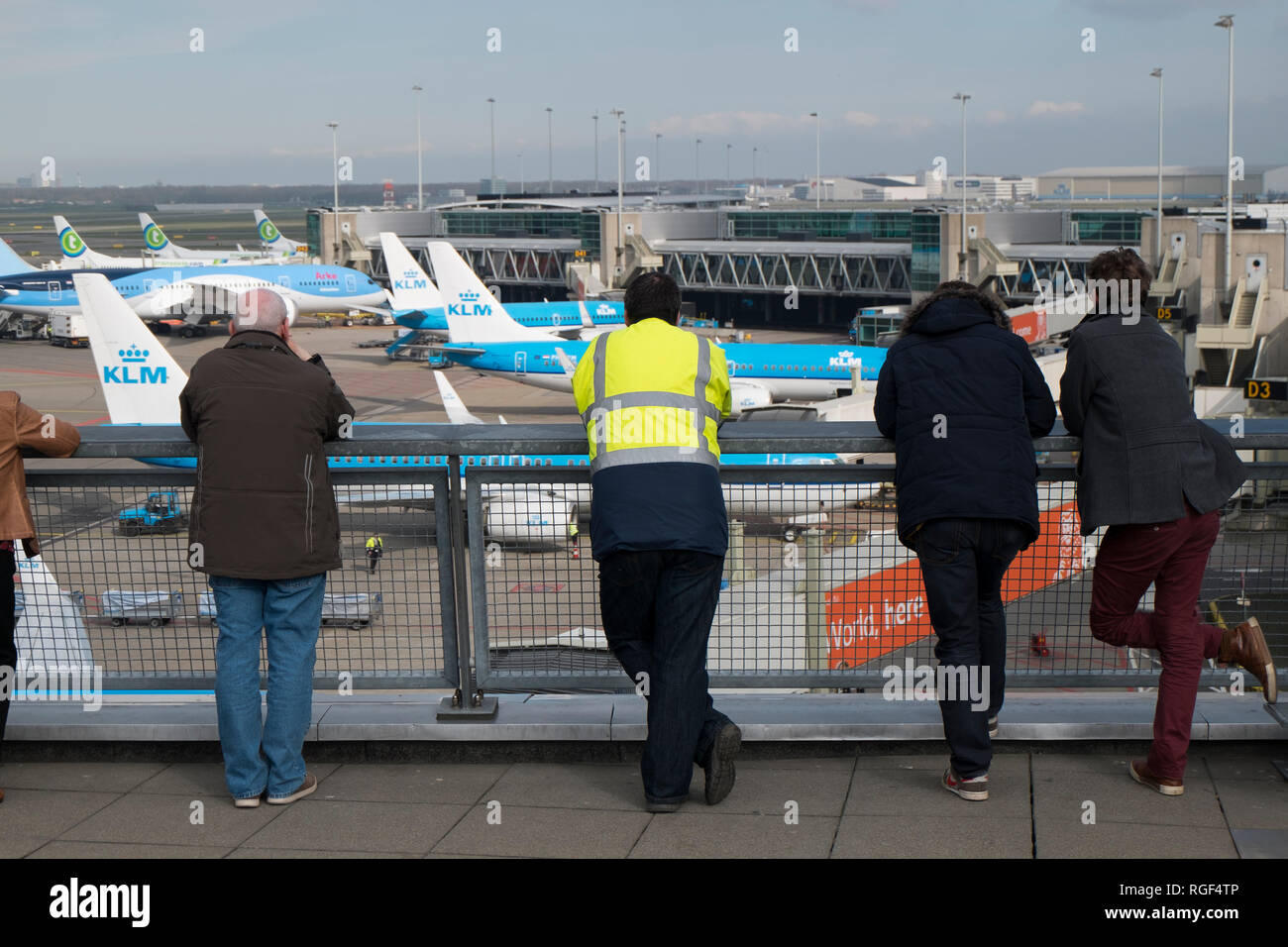 At the plane observation deck at Schiphol airport in Amsterdam in the Netherlands. People watching KLM planes take off. Stock Photo