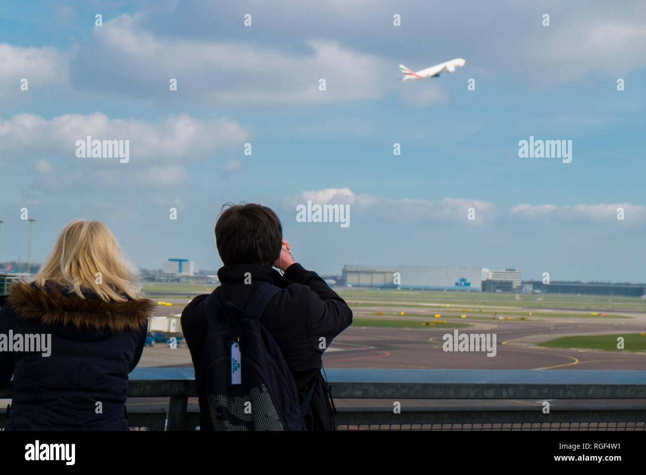 At the plane observation deck at Schiphol airport in Amsterdam in the Netherlands. People watching KLM planes take off. Stock Photo