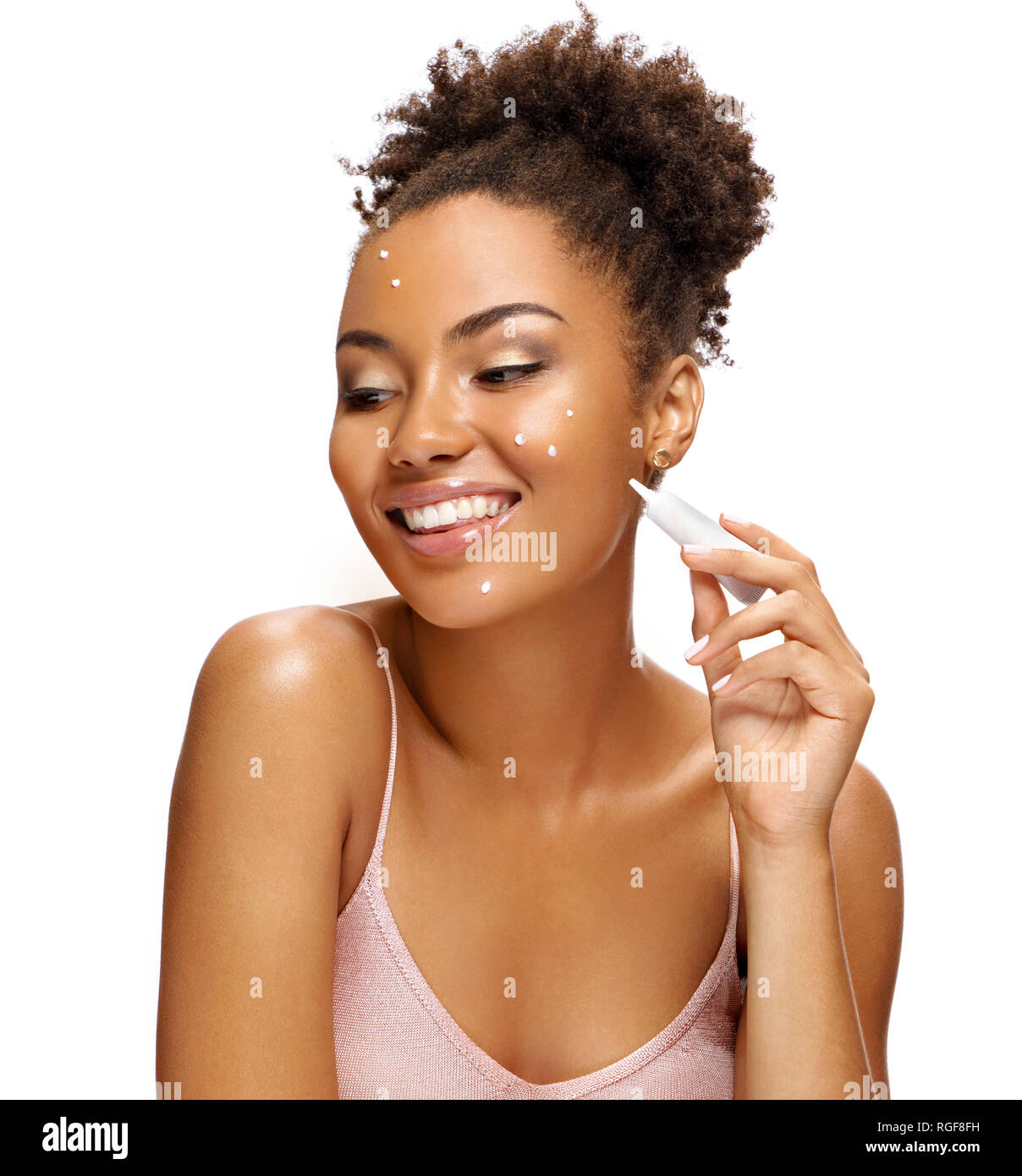 Happy girl applying treatment cream. Photo of smiling african american girl isolated on white background. Skin care concept Stock Photo