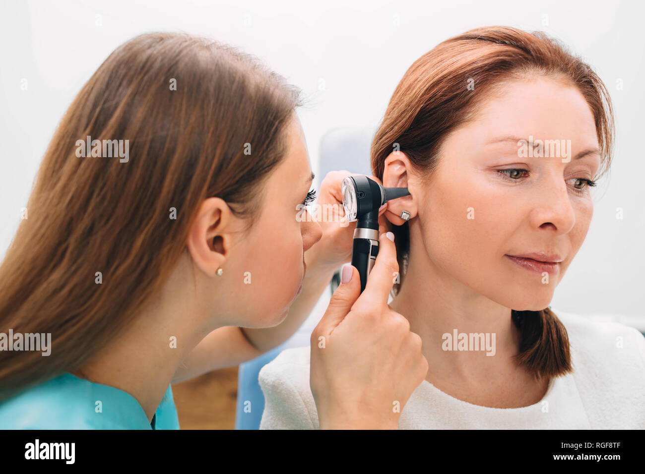 Mature woman getting ear exam at clinic Stock Photo