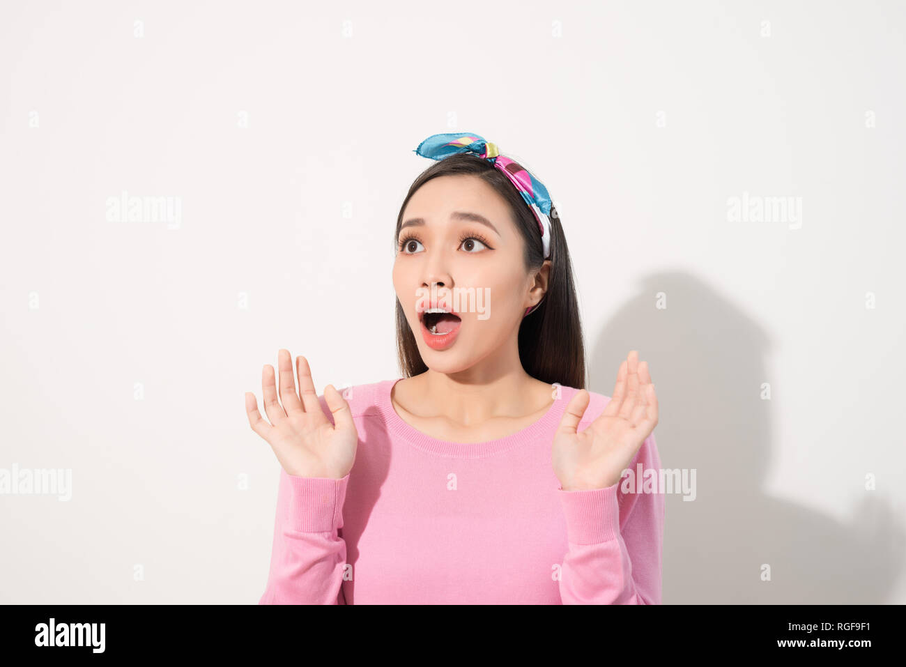 Asian Young Woman in Surprising Emotion, Face Look up above with opened mouth and hands, Emotional of Female Concept, Front view Stock Photo