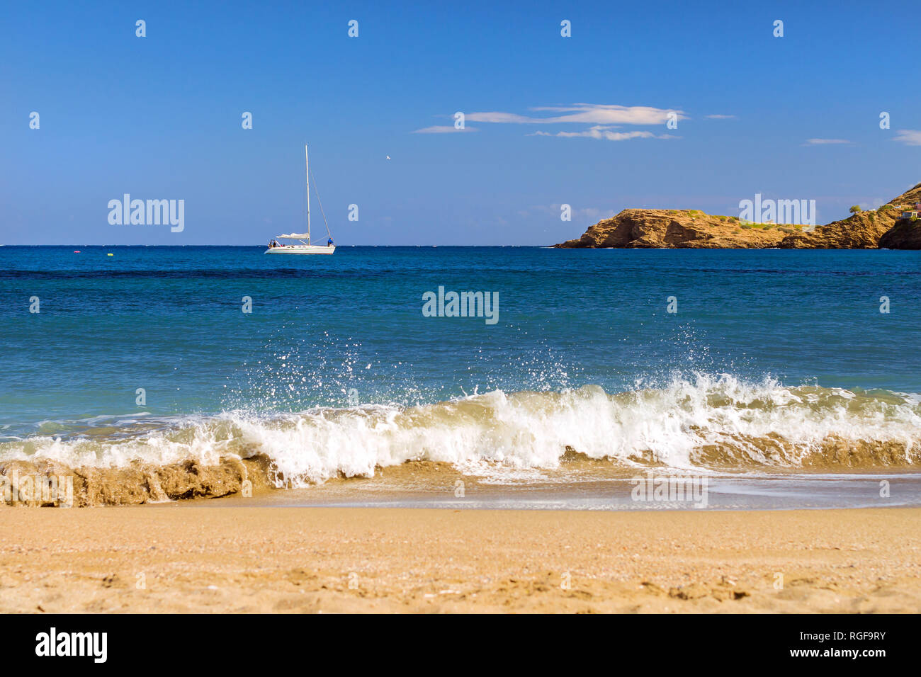Boat trips on a white sailing yacht. View from sunny Livadi beach in resort village Bali. Rethymno, Crete Greece. Extreme water sports as active recreation on sunny vacations Stock Photo
