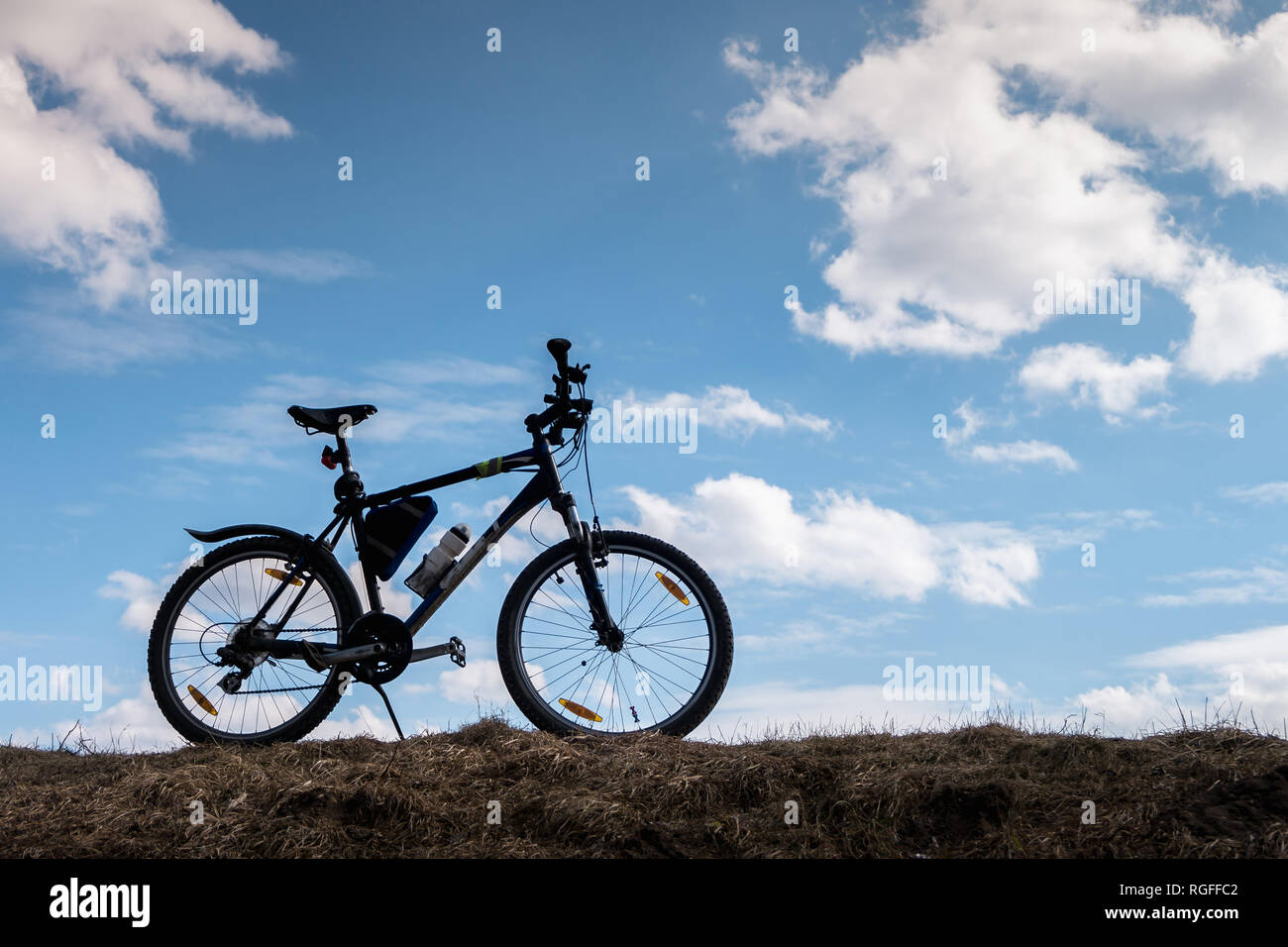 Bike silhouette in blue sky with clouds. symbol of independence and freedom Stock Photo