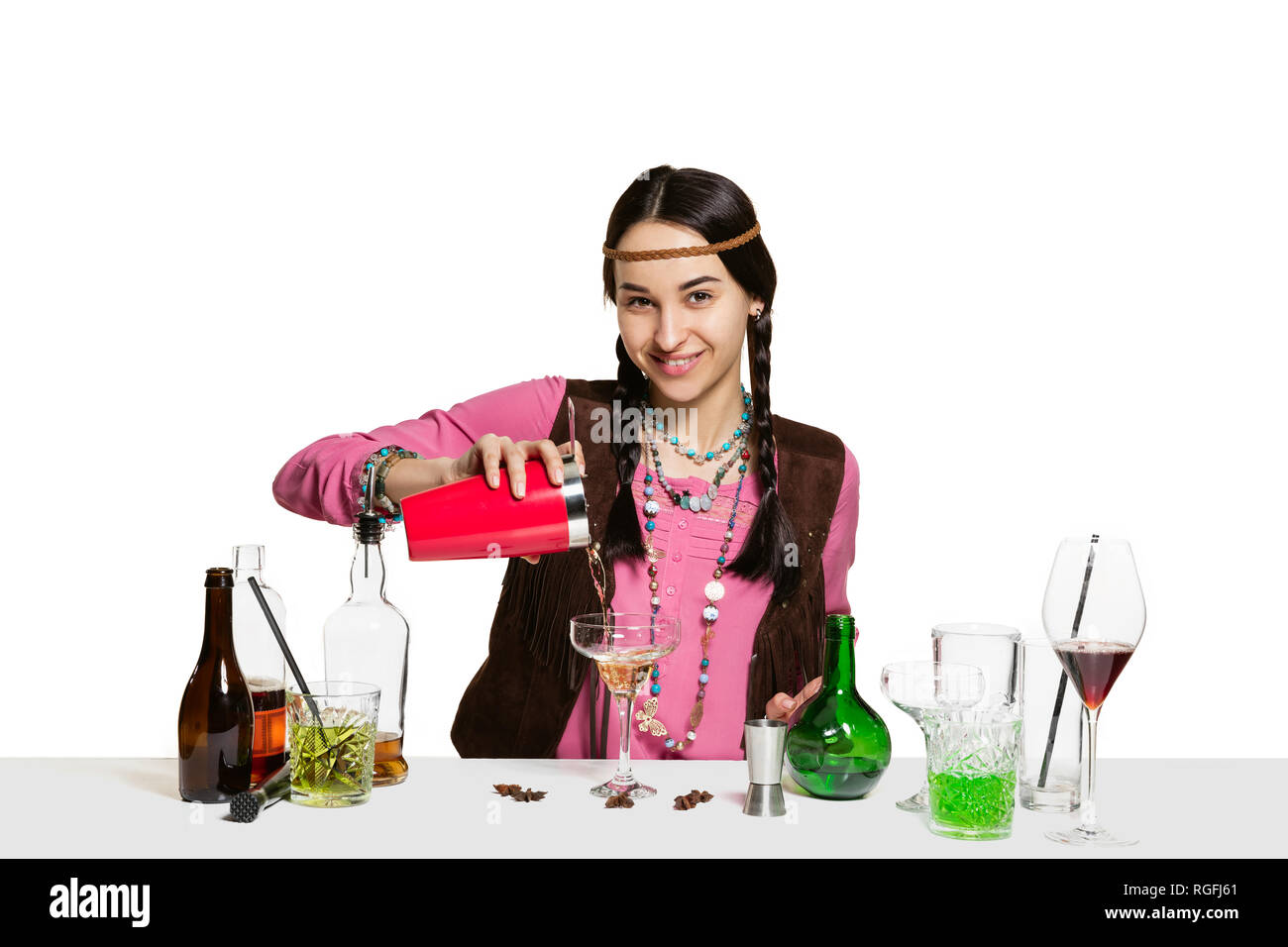 Wineglass stands on bar and woman bartender holds mixing cup and