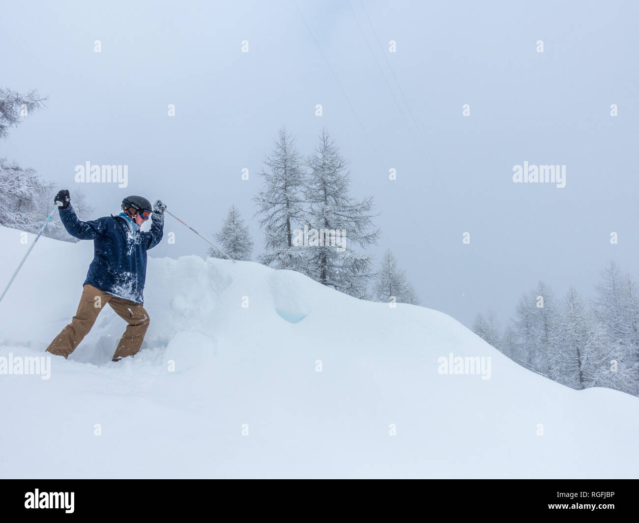 A young skier having fun stabbing snow with ski stick formation on slope in Alpes Alps Stock Photo
