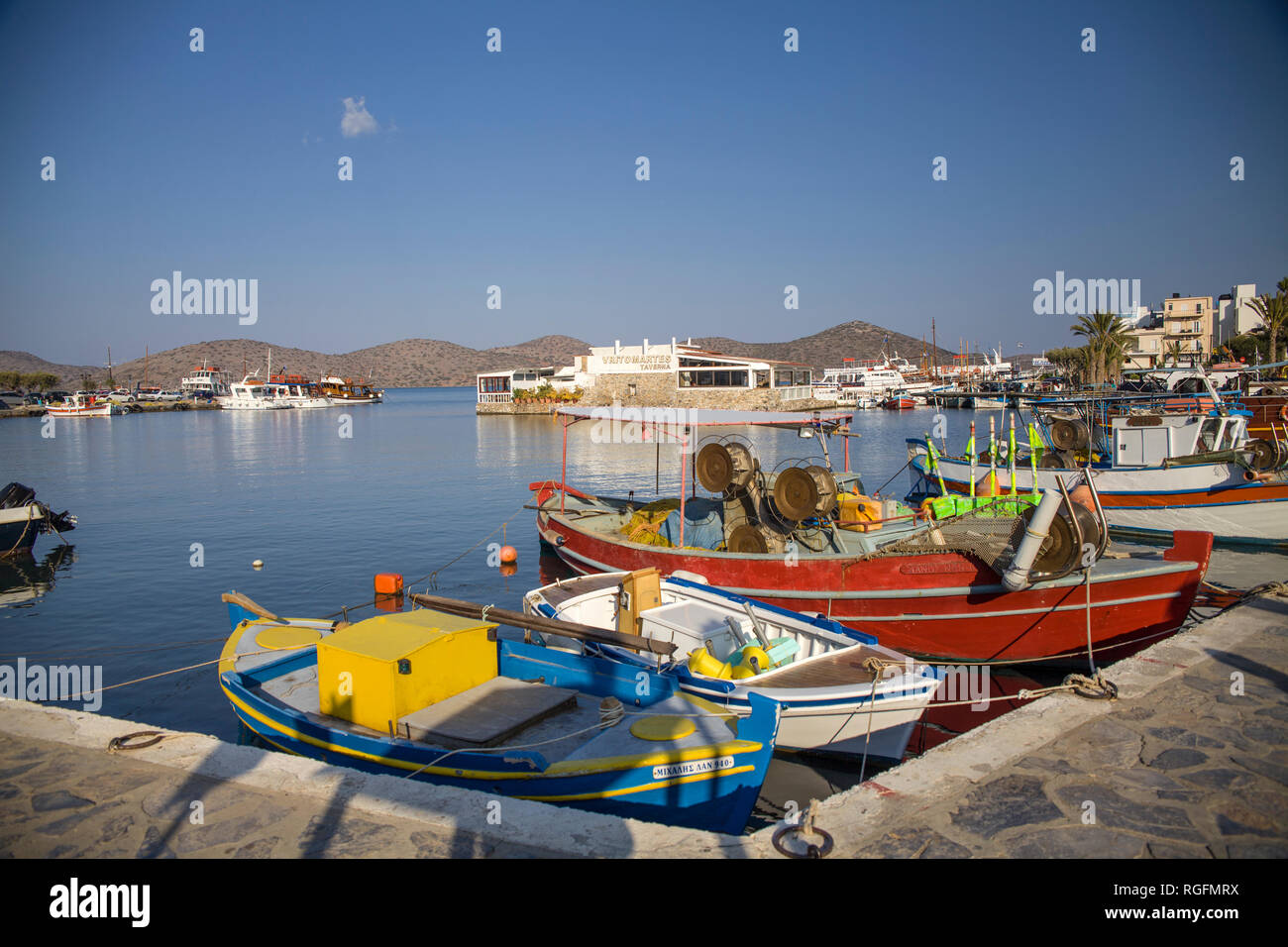 Small colorful fishing boats in the port. The harbor of Elunda in Crete, Greece. Stock Photo