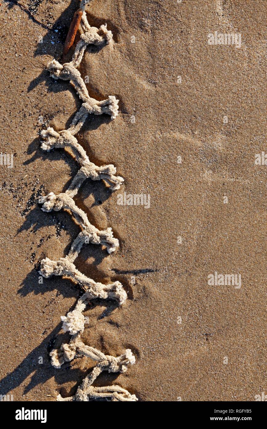 Knotted rope pattern on a sandy beach Stock Photo