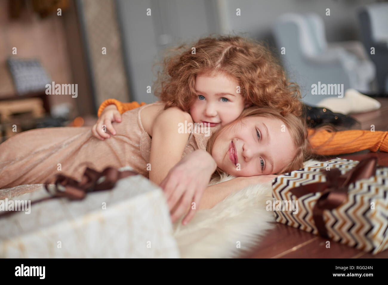 two pretty sisters are having fun in a cozy living room Stock Photo
