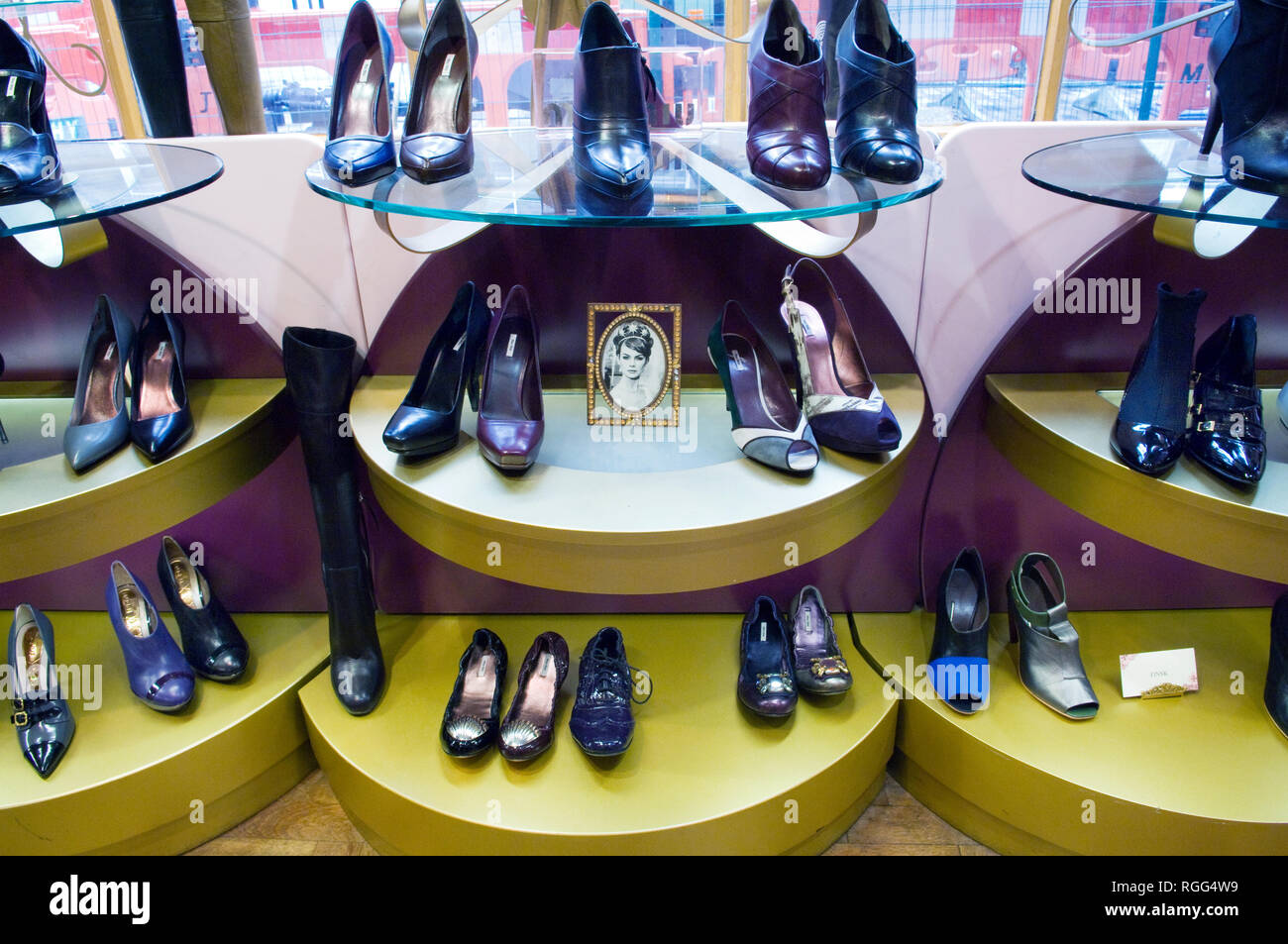 Rows of shoes at Poste Mistress, London, shoe shop with a picture of Audrey Hepburn in the middle Stock Photo