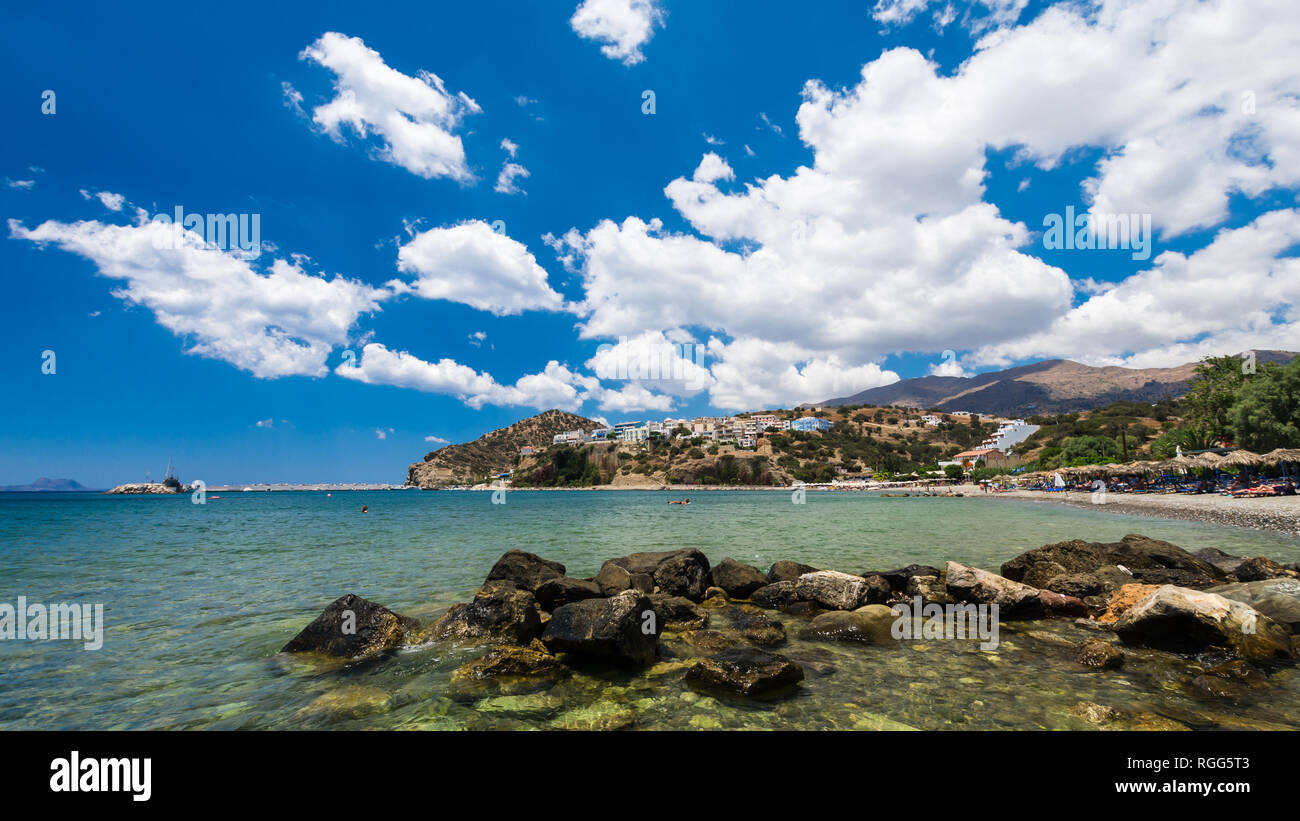 Agia Galini Beach in Crete island, Greece. Tourists relax and bath in crystal clear water of Agia Galini Beach. Stock Photo