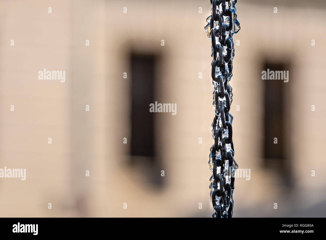 Icy vertical chain on blurred street background. Stock Photo